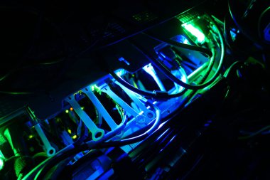 Renkli LED ışıklarıyla aydınlatılan sunucu altyapısının yakın plan görüntüsü, bir teknoloji kurulumunda kablo ve kabloların karmaşık düzenini gözler önüne seriyor.
