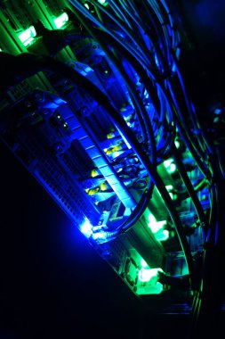 Canlı neon ışıklarıyla aydınlatılan sunucu kablolarının yakın görüntüsü. Görüntü, teknolojinin ve dijital bağlantının karmaşık detaylarını gösteriyor..