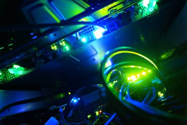 Yeşil ve mavi renkte renkli LED ışıkları olan bilgisayar donanımının yakın görüntüsü, kablo görüntüsü ve modern teknoloji kurulumunda parlayan bileşenler.