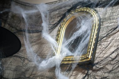 Örümcek ağlarıyla örülmüş rahatsız edici derecede güzel bir klasik ayna her türlü ürkütücü dekora ürkütücü bir dokunuş ekler. Cadılar Bayramı temaları ve gizemli atmosferler için mükemmel..