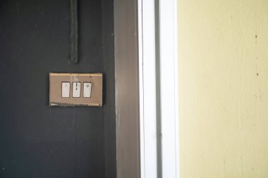 Modern bir iç duvarda ışık düğmelerinin yakın plan görüntüsü, ev geliştirme temaları için ideal renk ve minimalist tasarım karışımını sergiliyor.