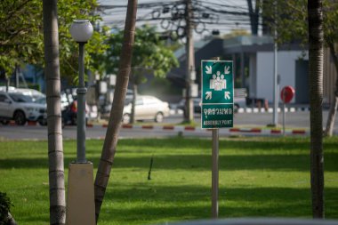 Parktaki acil durum işaretinin net bir görüntüsü yeşil çevre ve kentsel unsurların bulunduğu acil durumlarda güvenli bir yer olduğunu gösteriyor..