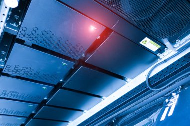 Modern sunucu rafında parlak siyah paneller ve gelişmiş teknoloji var. Profesyonel bir ortamda dijital altyapıyı ve sunucu yönetimini göstermek için ideal.