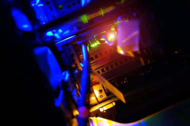 Bir bilgisayar sunucusunun içinde canlı bir görüntü renkli ışıklar ve karmaşık devreler sergiliyor, modern teknoloji ve veri işlemeyi temsil ediyor.