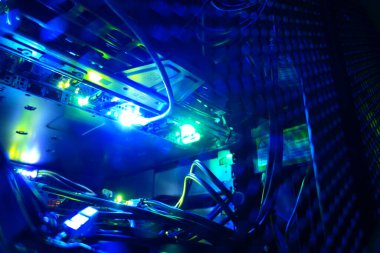 Canlı mavi ışıkların büyüleyici yakın çekimi karmaşık bilgisayar donanımlarını aydınlatıyor, dijital teknoloji ve elektronik teknolojinin karmaşıklığını gözler önüne seriyor..