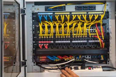 Modern teknoloji ve altyapı yönetiminin karmaşıklığını gözler önüne seren, bir sunucu rafında düzenlenmiş ağ kablolarının yakın plan görüntüsü.