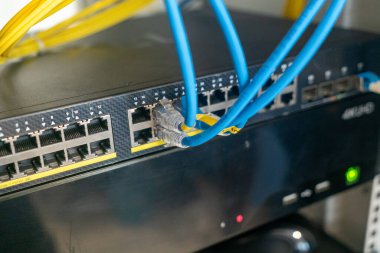 Bağlı ethernet kablolarıyla bir ağ anahtarının yakın plan görüntüsü modern altyapıda veri iletişimi ve bağlantı için kullanılan temel donanımı gösteriyor.