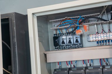 Elektrik kontrol panelinin ayrıntılı görüntüsü kablolama, anahtarlar ve devre kesiciler. Endüstriyel bakım ve teknoloji için mükemmel..