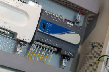 Otomasyon ve işletim verimliliği için gerekli karmaşık kablolama ve elektronik bileşenleri gösteren endüstriyel kontrol panelinin yakın çekimi.