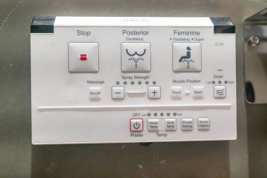 Bu resim, su sıcaklığı, sprey gücü ve kurutma seçenekleri için çeşitli ayarları gösteren, hijyen ve konforu destekleyen detaylı bir tuvalet bidesi kontrol paneline sahiptir..