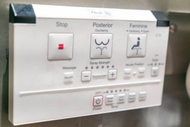 Bu resim, su püskürtme gücü ve sıcaklığı, hijyen ve konforu destekleyen çeşitli seçenekleri içeren modern bir bidet tuvalet ünitesi için bir kontrol panelini gösteriyor..