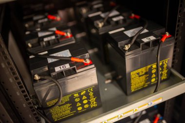 Rafta düzgün bir şekilde depolanmış piller, bağlantılarını ve etiketlerini sergiliyor, çeşitli endüstriyel uygulamalar için gerekli enerji kaynaklarını temsil ediyor.