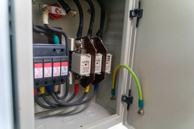 Kontrol panelinin içindeki elektriksel bileşenlerin yakın görüntüsü. Görüntü devre kesiciler, kablolama, kablo döşeme ve elektrik güvenlik elementleri içerir.