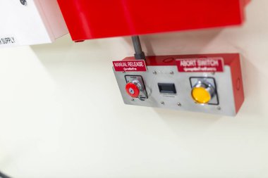 Çeşitli tesislerdeki güvenlik operasyonları için tasarlanmış, elle açma düğmesi ve iptal düğmesi içeren bir endüstriyel acil durum kontrol paneli..