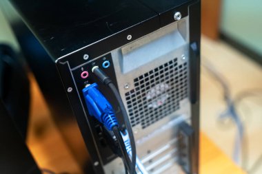 Görüntü, teknolojide ses, video ve ağ kurulumları için portları vurgulayan birden fazla kabloya sahip bir bilgisayarın arka panelini gösterir..