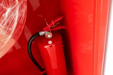 Güvenlik dolabına monte edilmiş kırmızı yangın söndürücünün yakın plan görüntüsü, acil durumlarda yangın güvenliği ve önleme için önemli bir araç olduğunu vurguluyor..