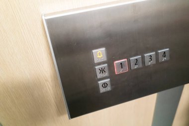 Modern bir asansör kontrol panelinin yakın plan görüntüsü. Parlak metal bir tasarımla zemin seçmek için düğmeleri vurguluyor. Mimari ve teknoloji temaları için ideal.
