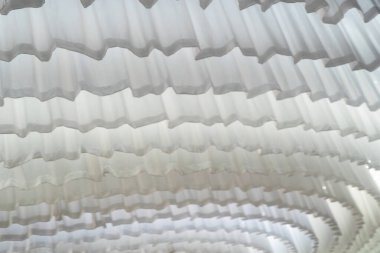 Bu resim, çeşitli tasarım projeleri ve arka planlar için mükemmel, yumuşak pileli ve dalgalı kıvrımlı beyaz kumaş örtüsünün zarif bir yakın çekimini sergiliyor..