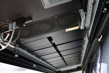 Bu resim, gelişmiş soğutma sistemleri, organize kablolama ve ideal performans için gerekli donanım bileşenlerini vurgulayan modern bir veri merkezi sunucu rafının içini gösterir..