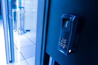 Parmak izi tarayıcısı ve tuş takımı içeren yüksek teknolojili bir kontrol sisteminin yakından görüntüsü. Bu fütüristik cihaz modern tesislerdeki güvenliği artırıyor..