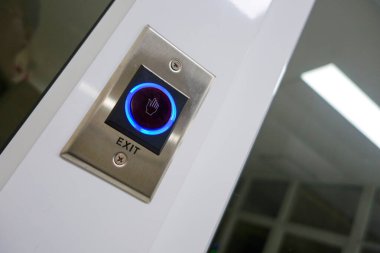 Bu resim, mavi ışık göstergesinin yer aldığı modern bir çıkış düğmesini gösteriyor. Kolayca erişebilmek için iç mekan ayarlarında parlak tasarım ve pratik kullanımı vurguluyor.