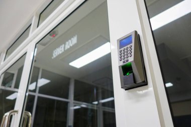 Modern bir erişim kontrol sistemi. Giriş kapısında bir tuş takımı ve tarayıcı var. Çağdaş mimari tasarımda güvenlik teknolojisini vurguluyor..