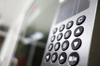 Bu resim, bir mikrodalga kontrol panelinin yakın görüntüsünü, düğmeleri ve sayısal tuş takımını vurguluyor, modern mutfak teknolojisini ve yemek pişirme kolaylığını iletiyor.