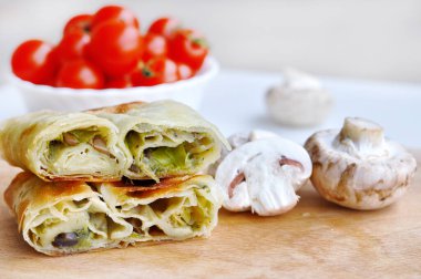 Ev yapımı mantar turtası. Pırasa ve mantarla doldurulmuş taze lezzetli turta. Tahta bir tabakta servis ediliyor.