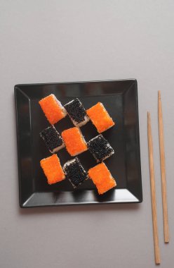 Koyu arkaplanda tabaktaki suşi