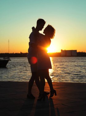  Kumsalda gün batımında dans eden mutlu çift.