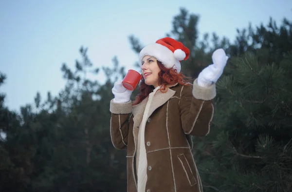 Mulher Sorridente Santa Hat Bebe Chá Quente Floresta — Fotografia de Stock