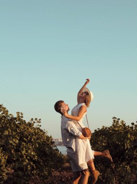 Gözlüklü çift üzüm bağında şarap içer.
