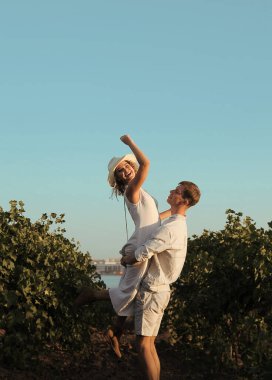 Gözlüklü çift üzüm bağında şarap içer.