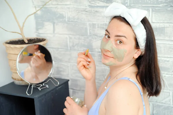 Mooie Jonge Vrouw Smeert Haar Gezicht Met Cosmetische Klei Een — Stockfoto