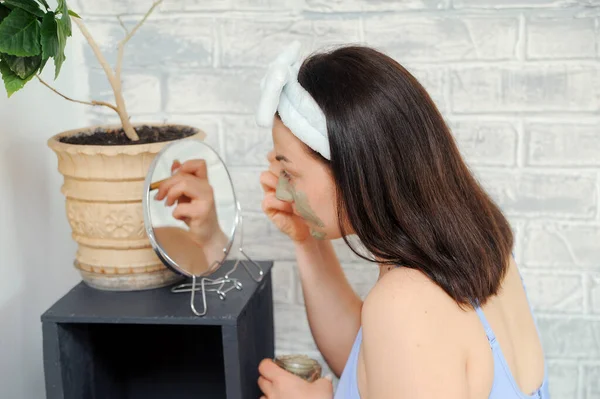 Mooie Jonge Vrouw Smeert Haar Gezicht Met Cosmetische Klei Een — Stockfoto