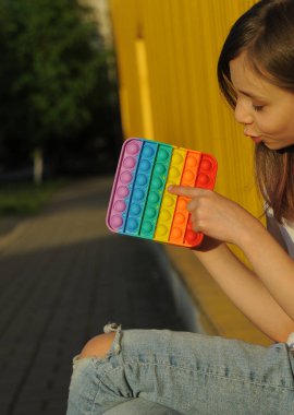 Çocuk sarı arka planda basit gamzeli oyuncakla oynar