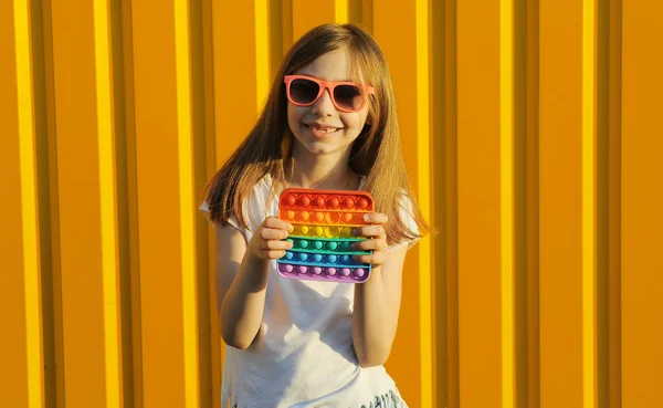 Dítě Hraje Jednoduchým Dolíčkem Hračka Žlutém Pozadí Barvy — Stock fotografie