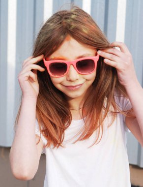 Küçük kız Holi festivalinde boyalarla eğleniyor.