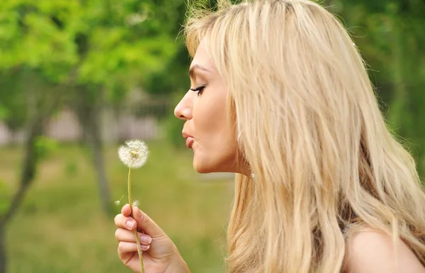 Portrait of young beautiful woman with a dandelion — Stock Photo, Image