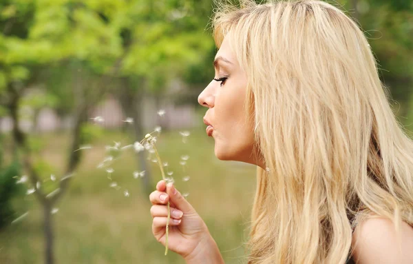 Young beautiful woman with a dandelion — Stock Photo, Image