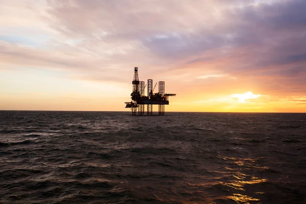 Piattaforma petrolifera al tramonto Foto Stock Royalty Free