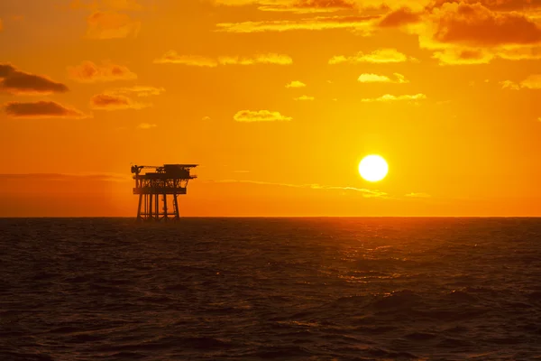 Нафтова платформа на заході сонця Ліцензійні Стокові Зображення