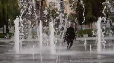 Neşeli, kaygısız Afrikalı eğleniyor ve dans ediyor. Afrika dansı kamera önünde. Pozitif Afro-Amerikan adam dans ediyor. Sokakta bir Afrikalı dans ediyor. Çeşmede dans et. 4K 'da çekilmiş.