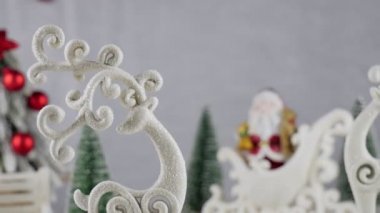 Beyaz arka planda geyik oyuncağı. Noel arkaplanı Noel Baba kızakta. Kırmızı taşaklı Noel ağacı. Noel karlı arka planı. Karlı arka planda Noel oyuncakları 