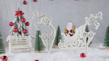 Noel arkaplanı. Beyaz arka planda geyik oyuncağı. Noel arkaplanı Noel Baba kızakta. Kırmızı taşaklı Noel ağacı. Karlı arka planda Noel süslemeleri 