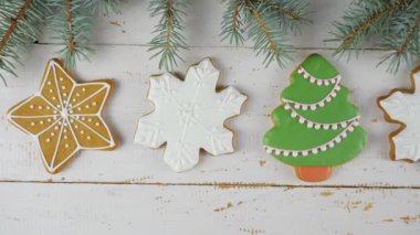 Noel için zencefilli kek süslemesi. Beyaz ahşap arka planda zencefilli kurabiye. Zencefilli kurabiyeler arka arkaya. Yukarıdan bak. 4K 'da çekilmiş.
