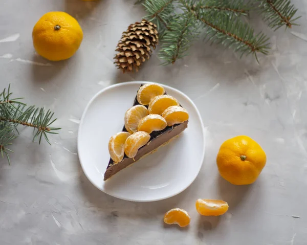 kek arkaplanı. Taze çikolatalı pasta arka planı. Ev yapımı çikolatalı kek. Mandalina ve ladin dalları. Yukarıdan bak. kopyalanmış