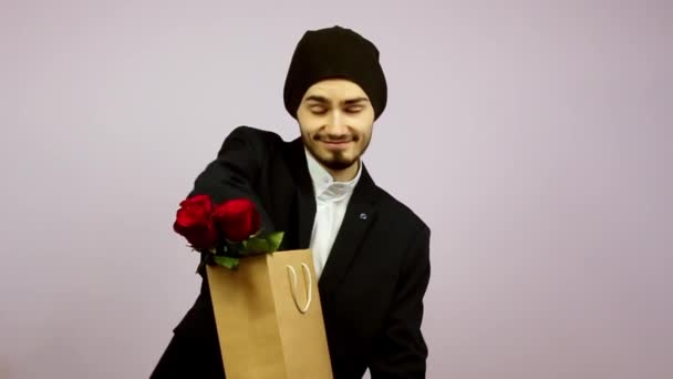 Walentynki Facet Brodą Trzyma Paczkę Czerwonymi Różami Dłoniach Wyciąga Prezent — Wideo stockowe