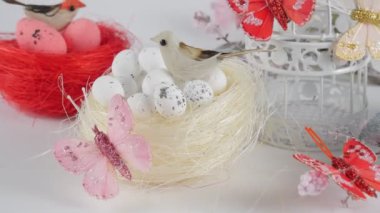 Paskalya geçmişi. Beyaz arka planda yumurtaları olan çeşitli yuvaları var. Paskalya tatili. Bahar konsepti. 