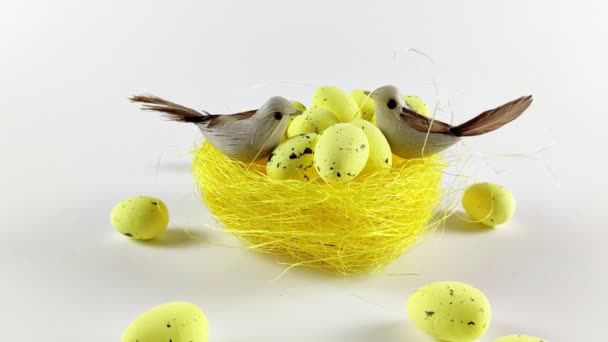 白い背景に黄色の卵を持つイースター背景の黄色の巣 イースター休暇 春のコンセプト — ストック動画